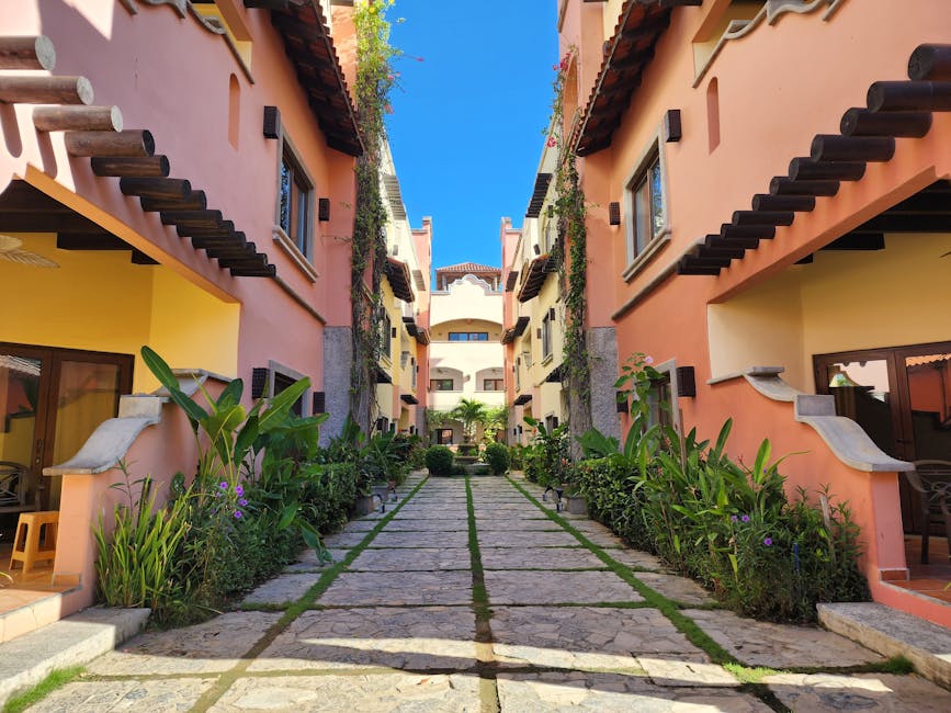 Explore lush greenery and distinctive architecture in this serene Mediterranean-style resort walkway.